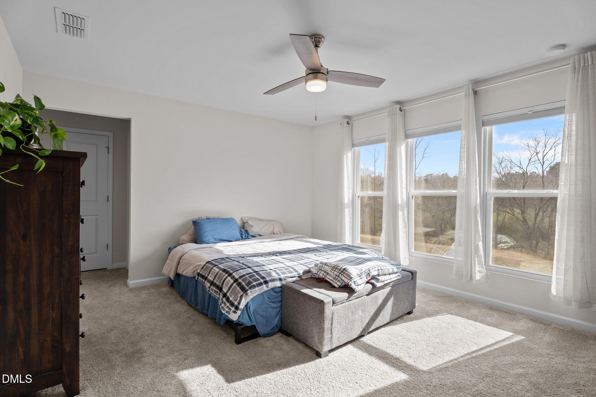 1572 Rhodes Pond Street Wendell, NC 27591 - Photo 18 of 44 a large bed sitting in a bedroom next to a window and a chandelier