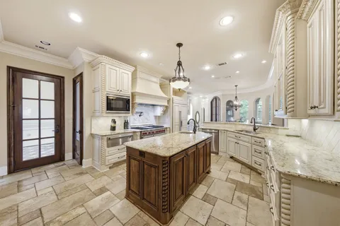 a large kitchen with stainless steel appliances granite countertop a large counter top and a stove