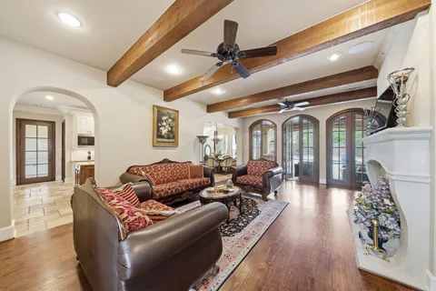 a living room with furniture ceiling fan and wooden floor