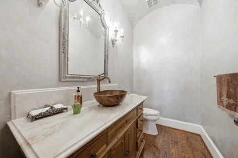 a bathroom with a granite countertop sink a toilet and a mirror
