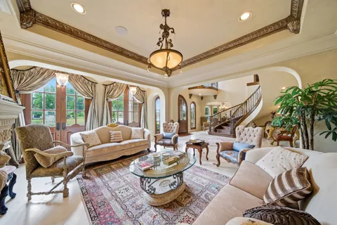 a living room with furniture a chandelier and a large window