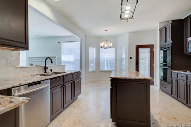 a kitchen with granite countertop a sink and cabinets