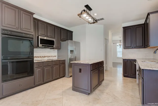 a kitchen with stainless steel appliances granite countertop wooden cabinets a stove top oven a sink and dishwasher