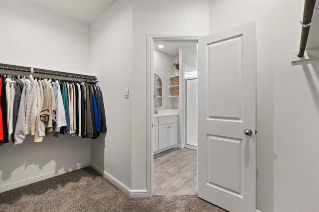 a view of walk in closet with clothes and shoes