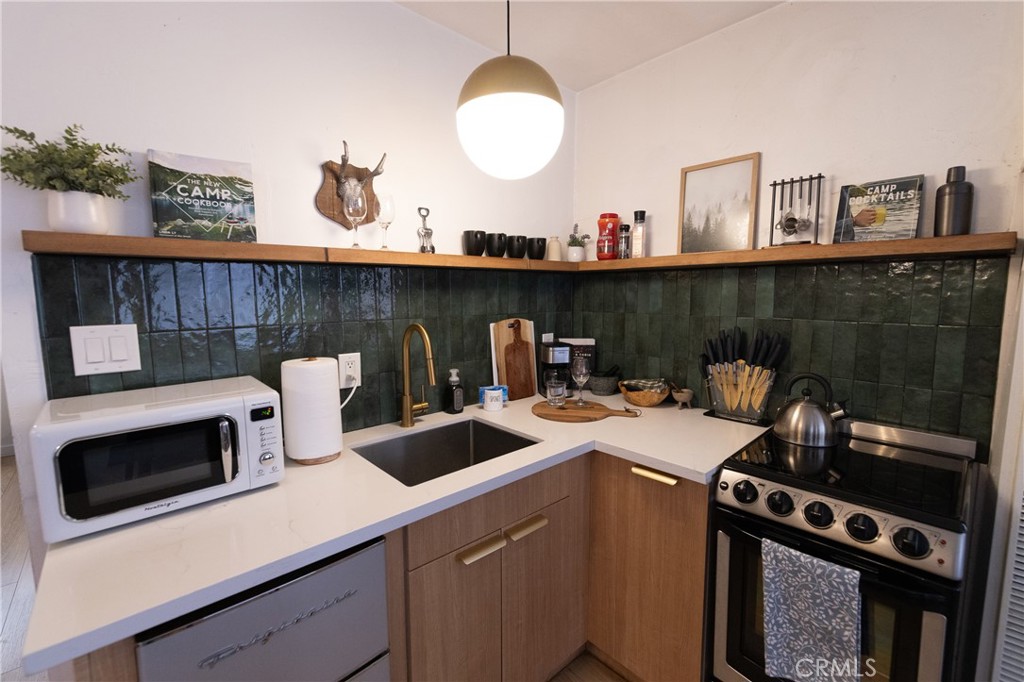 376 Riverside Avenue Sugarloaf, CA 92386 - Photo 11 of 28 a kitchen with a sink a stove and cabinets