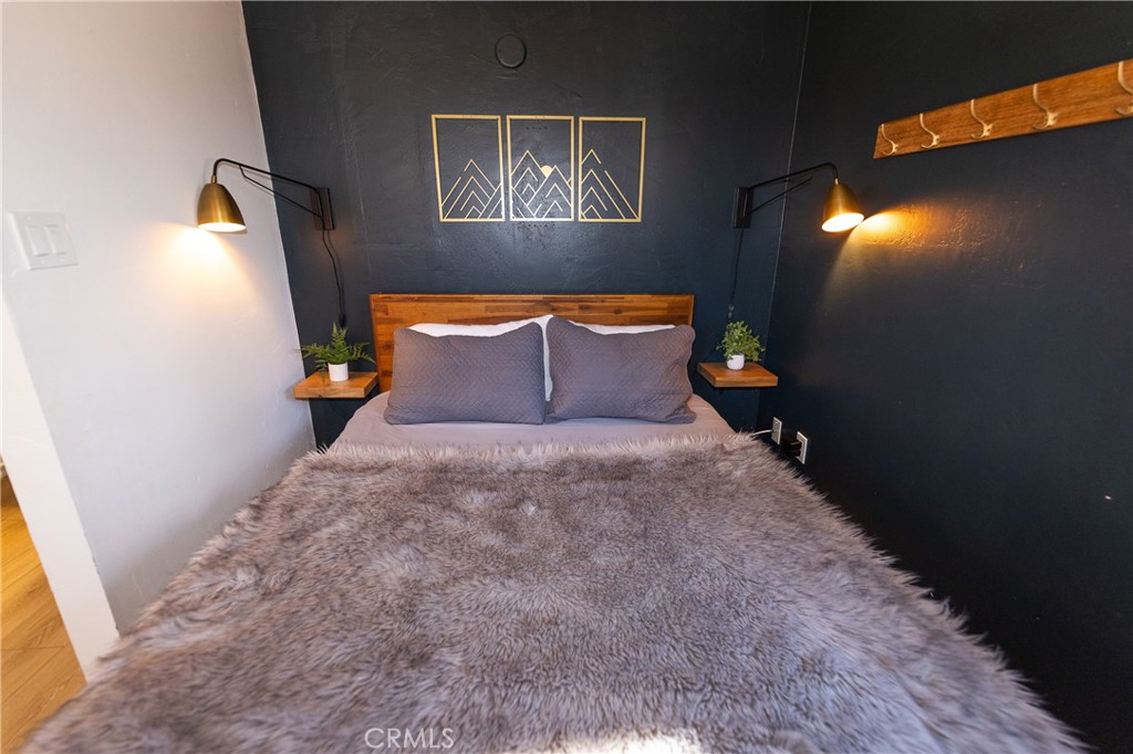 376 Riverside Avenue Sugarloaf, CA 92386 - Photo 21 of 28 a bed room with a bed and a painting on the wall