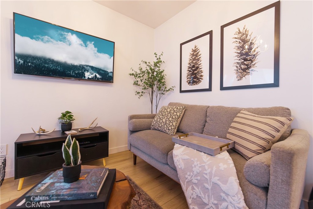 376 Riverside Avenue Sugarloaf, CA 92386 - Photo 7 of 28 a living room with furniture a flat screen tv and a wall painting