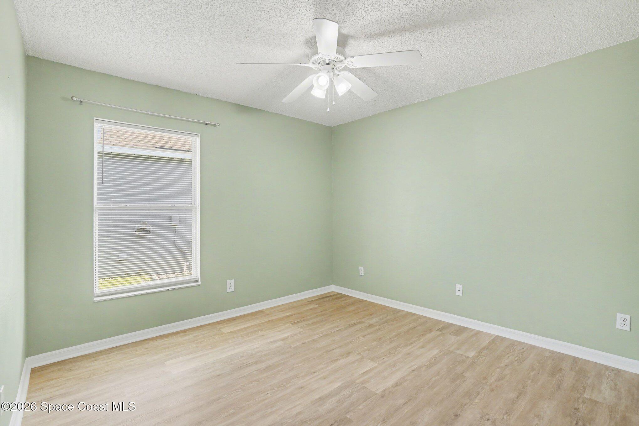2547 Deercroft Drive Melbourne, FL 32940 - Photo 17 of 35 an empty room with a window and a fan