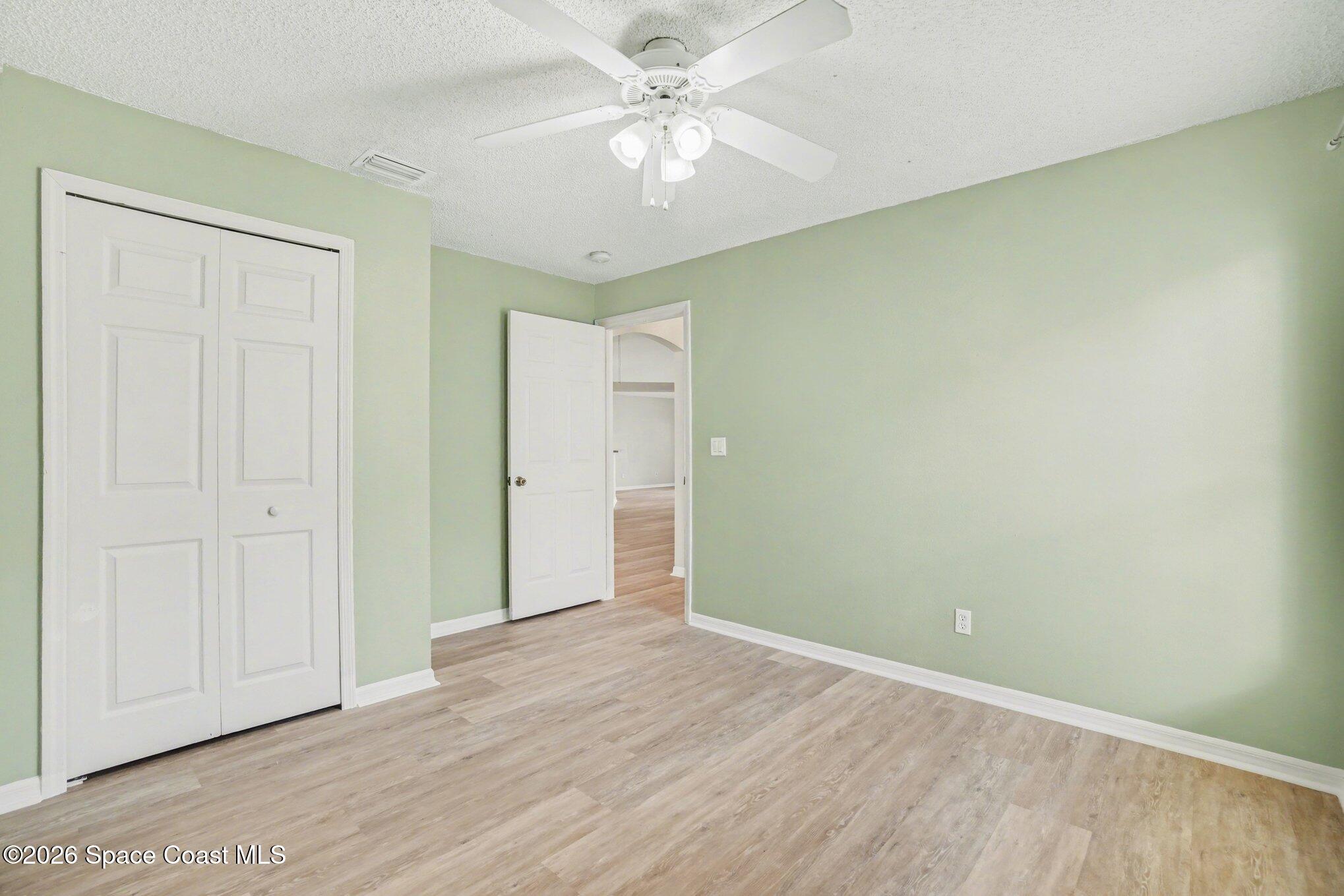 2547 Deercroft Drive Melbourne, FL 32940 - Photo 18 of 35 an empty room with closet and a chandelier fan