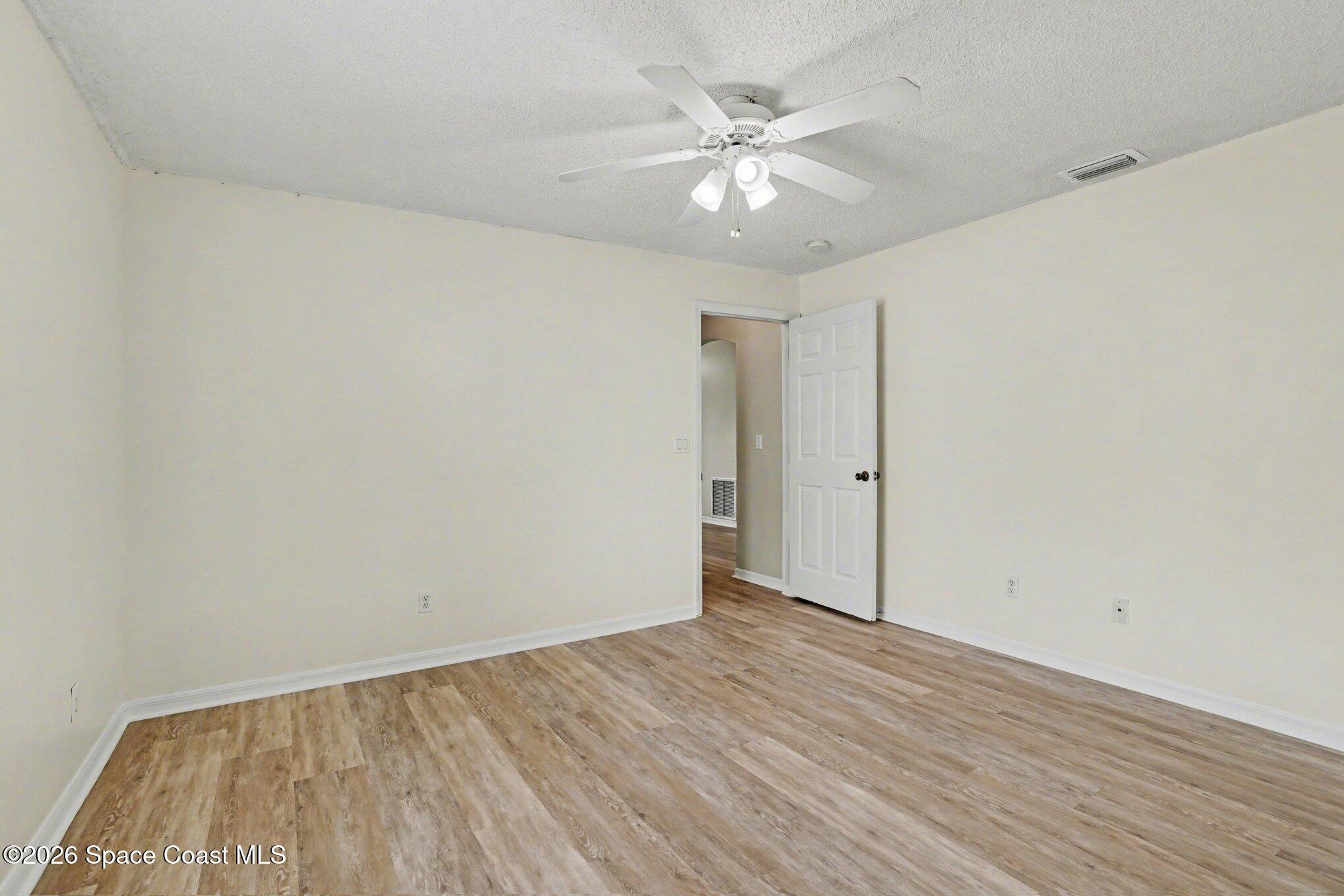 2547 Deercroft Drive Melbourne, FL 32940 - Photo 20 of 35 a view of an empty room with wooden floor