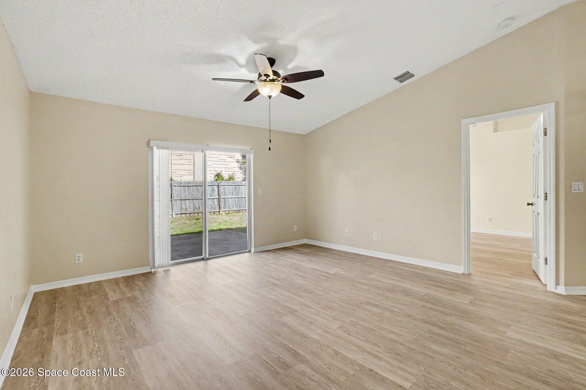 2547 Deercroft Drive Melbourne, FL 32940 - Photo 23 of 35 a view of an empty room with wooden floor and a window