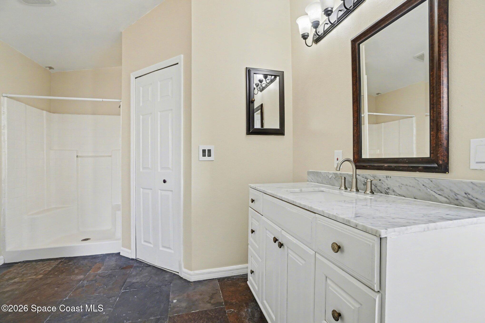 2547 Deercroft Drive Melbourne, FL 32940 - Photo 24 of 35 a bathroom with a granite countertop sink and a mirror