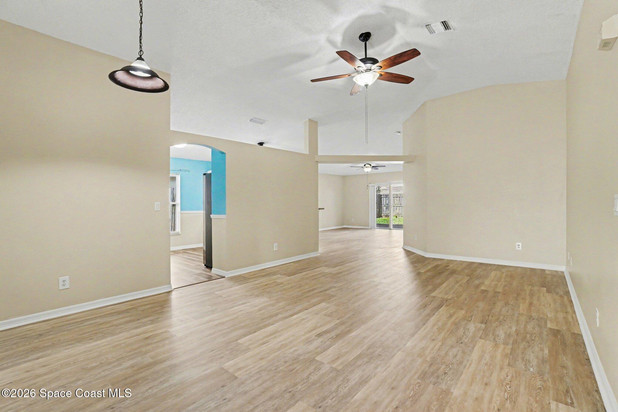 2547 Deercroft Drive Melbourne, FL 32940 - Photo 4 of 35 a view of empty room with wooden floor and ceiling fan