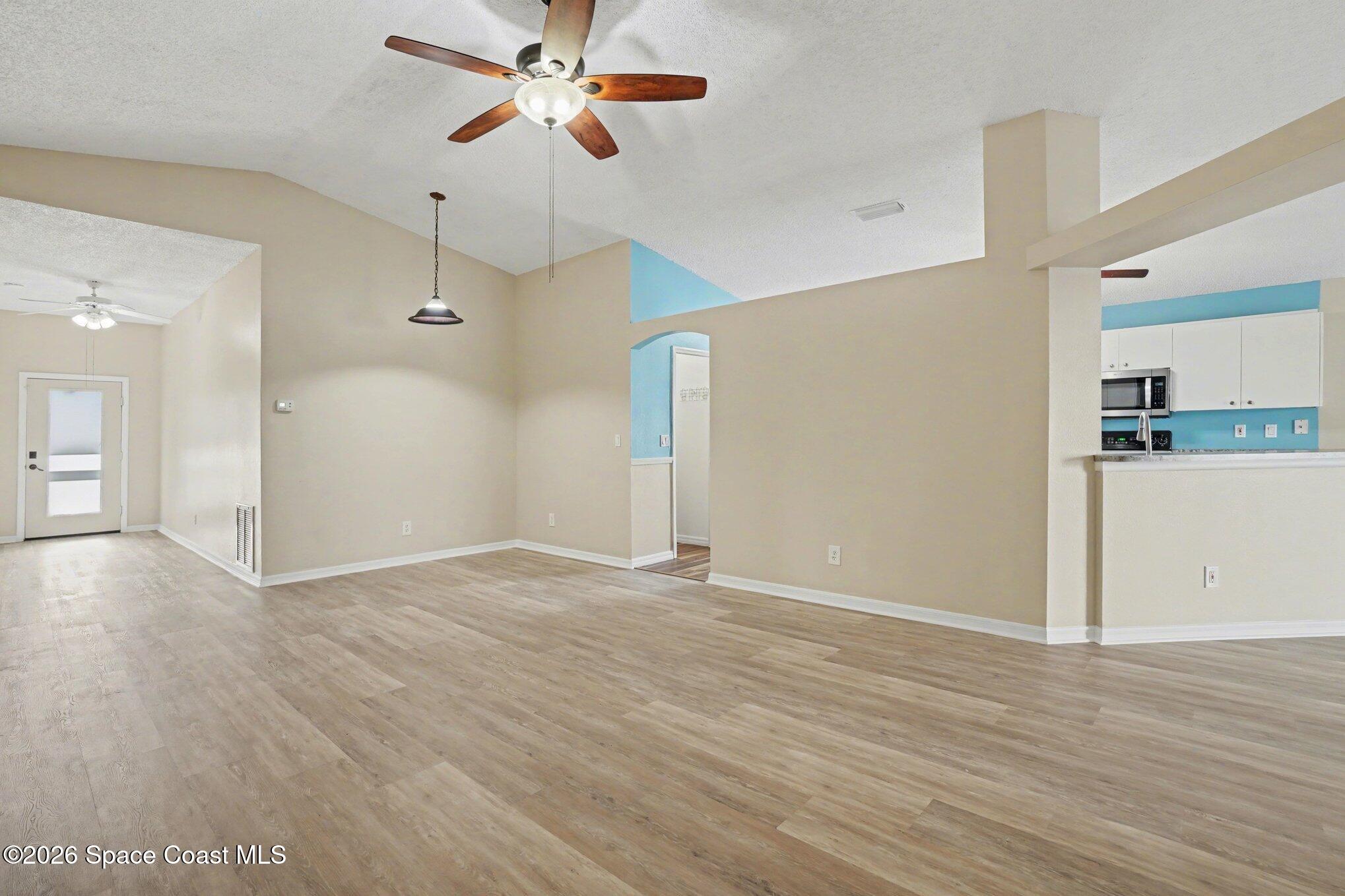 2547 Deercroft Drive Melbourne, FL 32940 - Photo 6 of 35 a view of a room with wooden floor and a ceiling fan