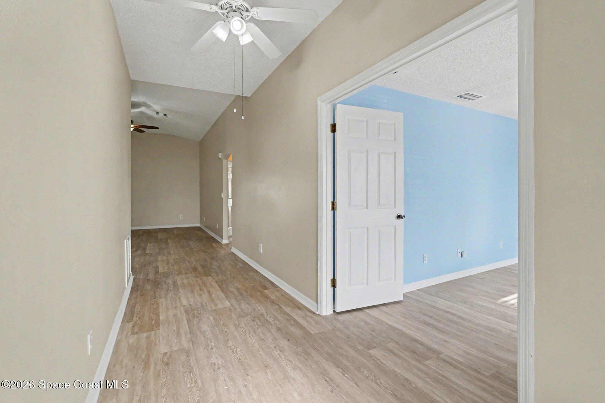 2547 Deercroft Drive Melbourne, FL 32940 - Photo 8 of 35 an empty room with wooden floor and ceiling fan