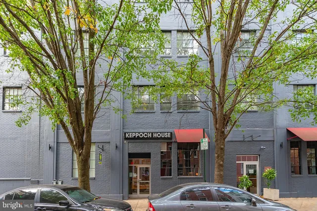 a front view of a building with trees