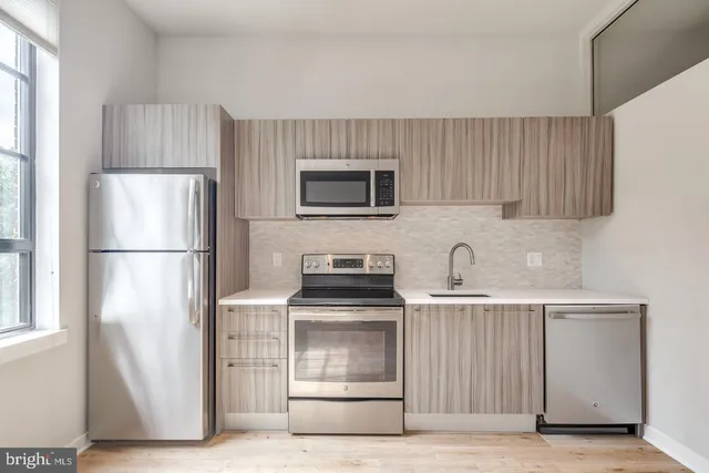 a kitchen with cabinets and stainless steel appliances
