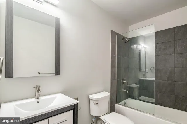 a bathroom with a sink toilet a mirror and shower
