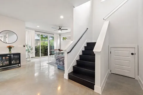 a view of a livingroom with wooden floor a fireplace and entryway