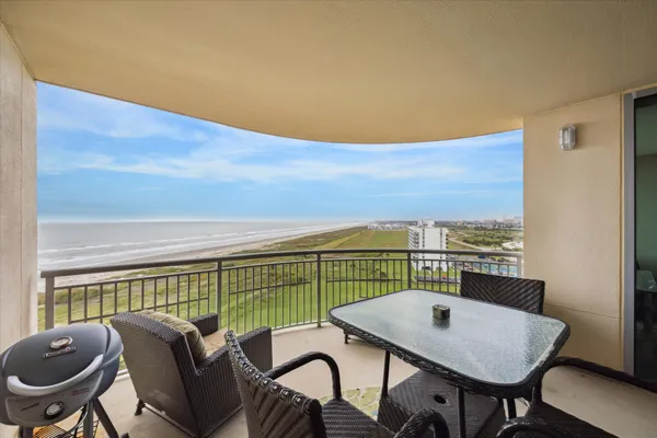 a view of a balcony with a table and chairs