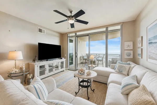 a living room with furniture a flat screen tv and a large window