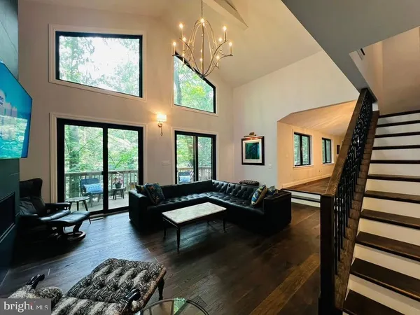 a living room with furniture and floor to ceiling windows
