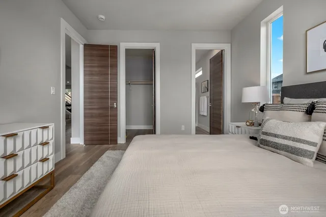 a view of a bedroom with a bed and wooden floor