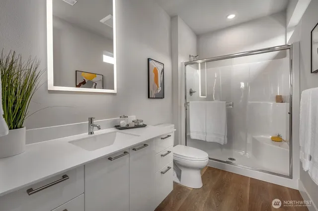 a bathroom with a sink a toilet and shower