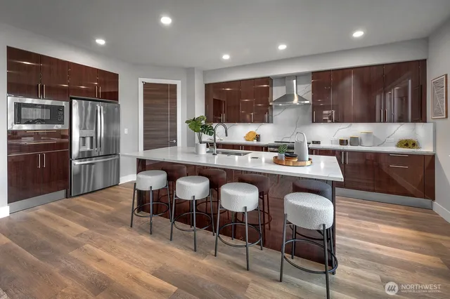 a kitchen with stainless steel appliances granite countertop a table chairs sink refrigerator and microwave