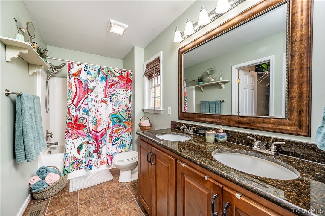 14490 Meade Road Amelia Court House, VA 23002 - Photo 15 of 25 a bathroom with a granite countertop sink a toilet and a shower curtain