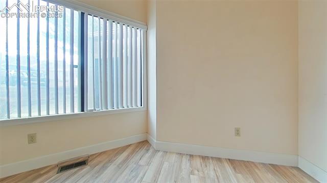 460 Autumn Ridge Circle, Unit D Colorado Springs, CO 80906 - Photo 11 of 38 Empty room with baseboards, visible vents, and wood finished floors