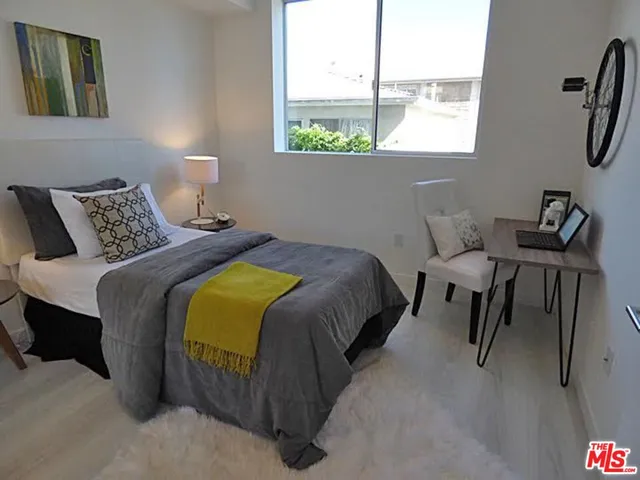 a bedroom with a bed a mirror and a window