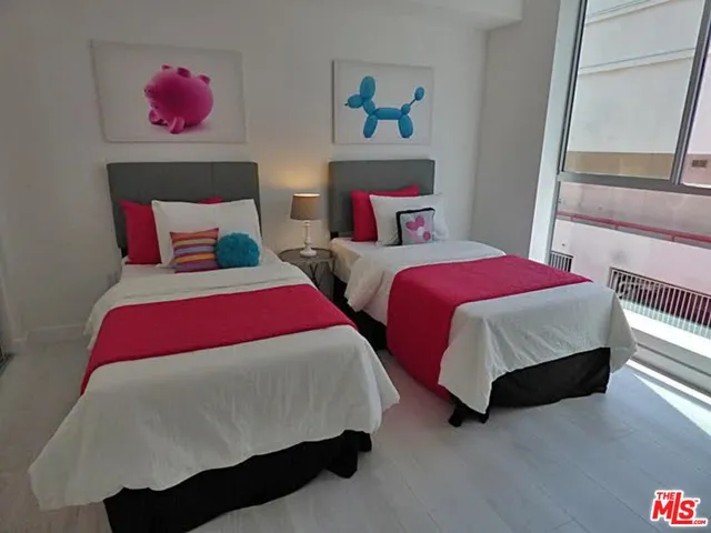 a bedroom with two beds and painting on the wall