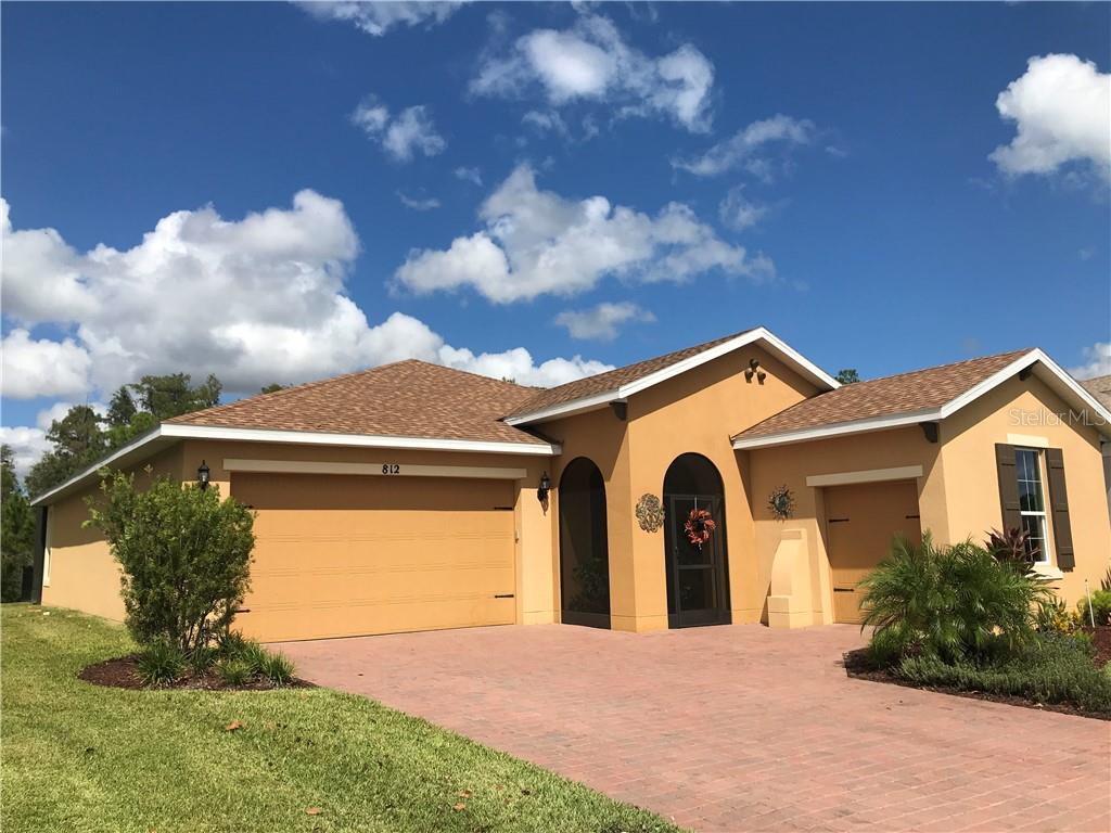 812 Pacific Ridge Road Poinciana, FL 34759 - Photo 1 of 1 a front view of a house with a yard and garage
