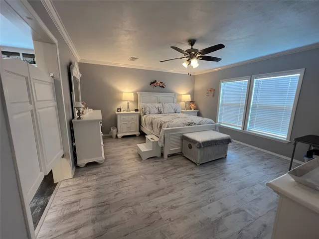 a spacious bedroom with a bed and a chandelier