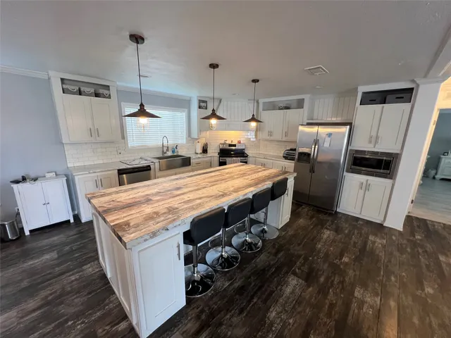 a kitchen with granite countertop a stove a sink dishwasher and a refrigerator