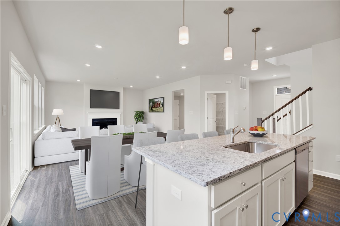 6454 Fennec Run Moseley, VA 23120 - Photo 5 of 23 a kitchen with center island white cabinets and wooden floor
