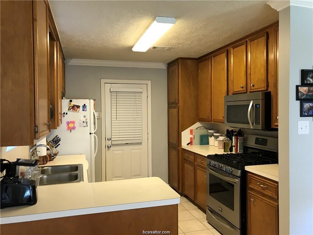2105 Pebblebrook Lane Bryan, TX 77807 - Photo 4 of 18 a kitchen with stainless steel appliances a stove a refrigerator sink and cabinets