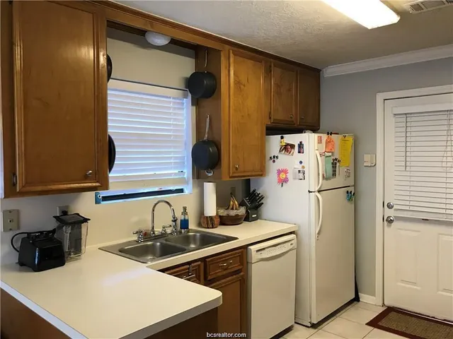 a kitchen with a sink a refrigerator and cabinets