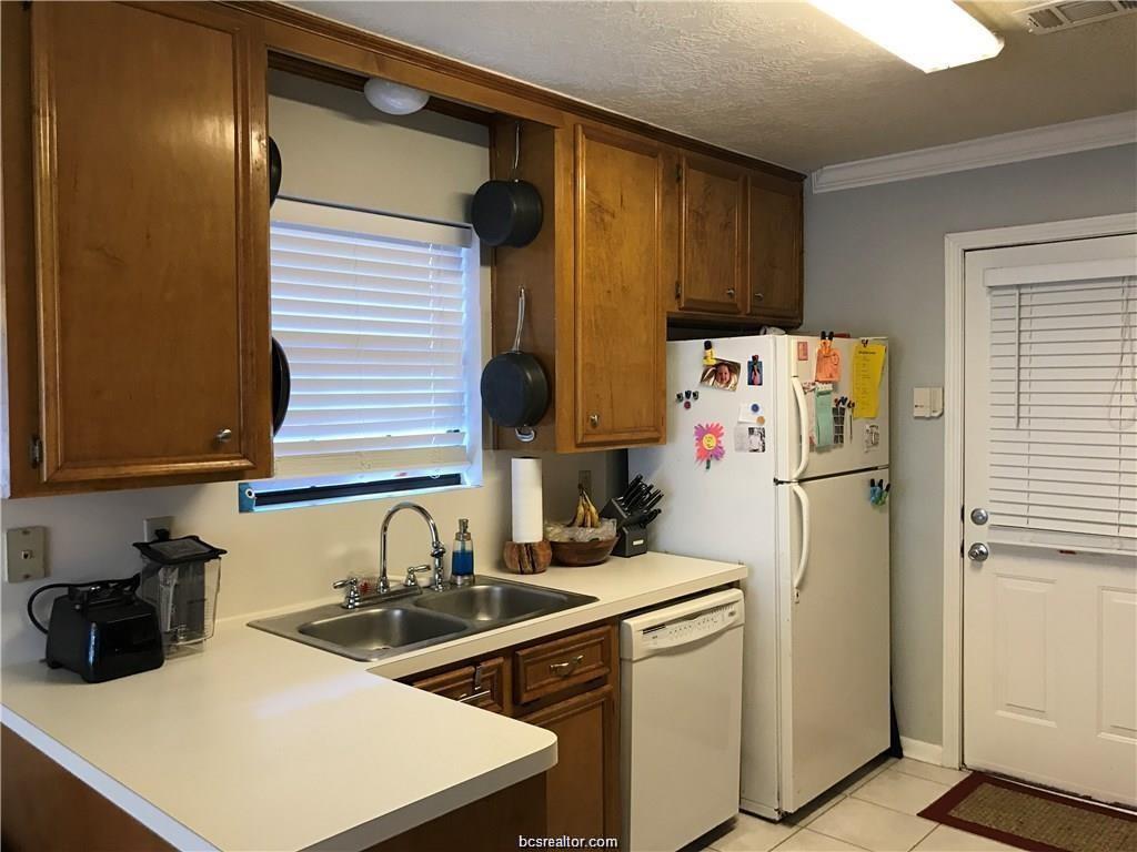 2105 Pebblebrook Lane Bryan, TX 77807 - Photo 6 of 18 a kitchen with a sink a refrigerator and cabinets