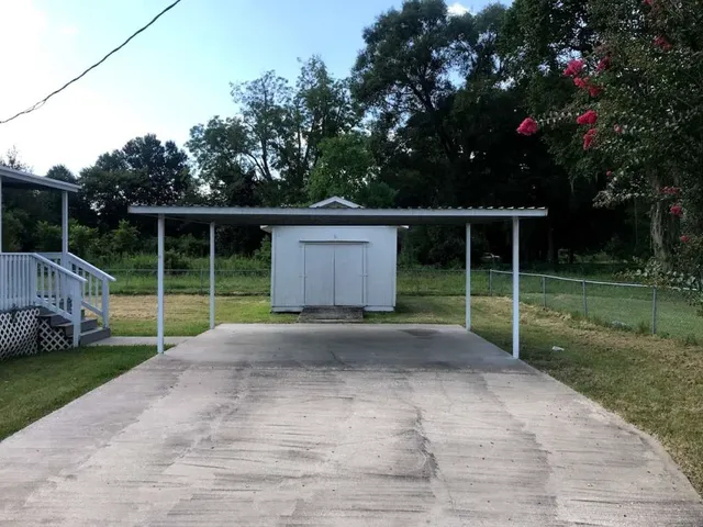 a view of a house with backyard and a garden