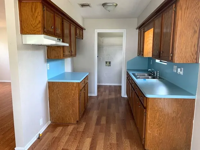 a kitchen with stainless steel appliances granite countertop a sink a stove top oven a counter space and cabinets