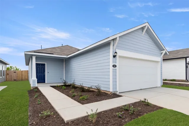 a view of a white house next to a yard