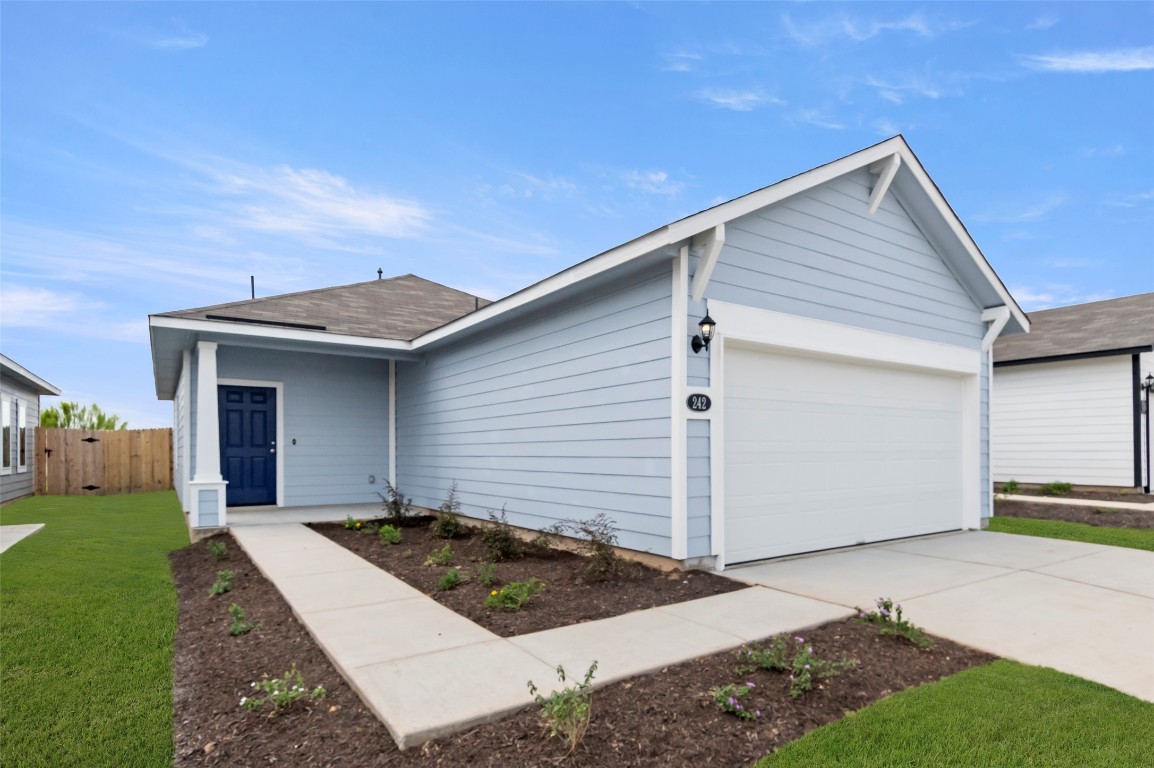 a view of a white house next to a yard