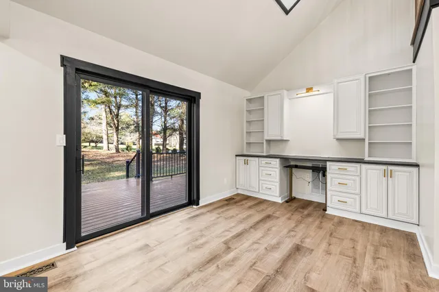 a large white kitchen with kitchen island a stove a sink a dining table and chairs