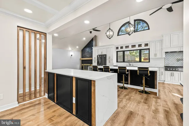 a kitchen with white cabinets and black appliances