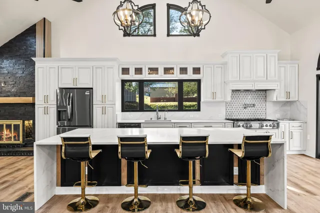 a kitchen with stainless steel appliances granite countertop a sink a stove and a wooden floors
