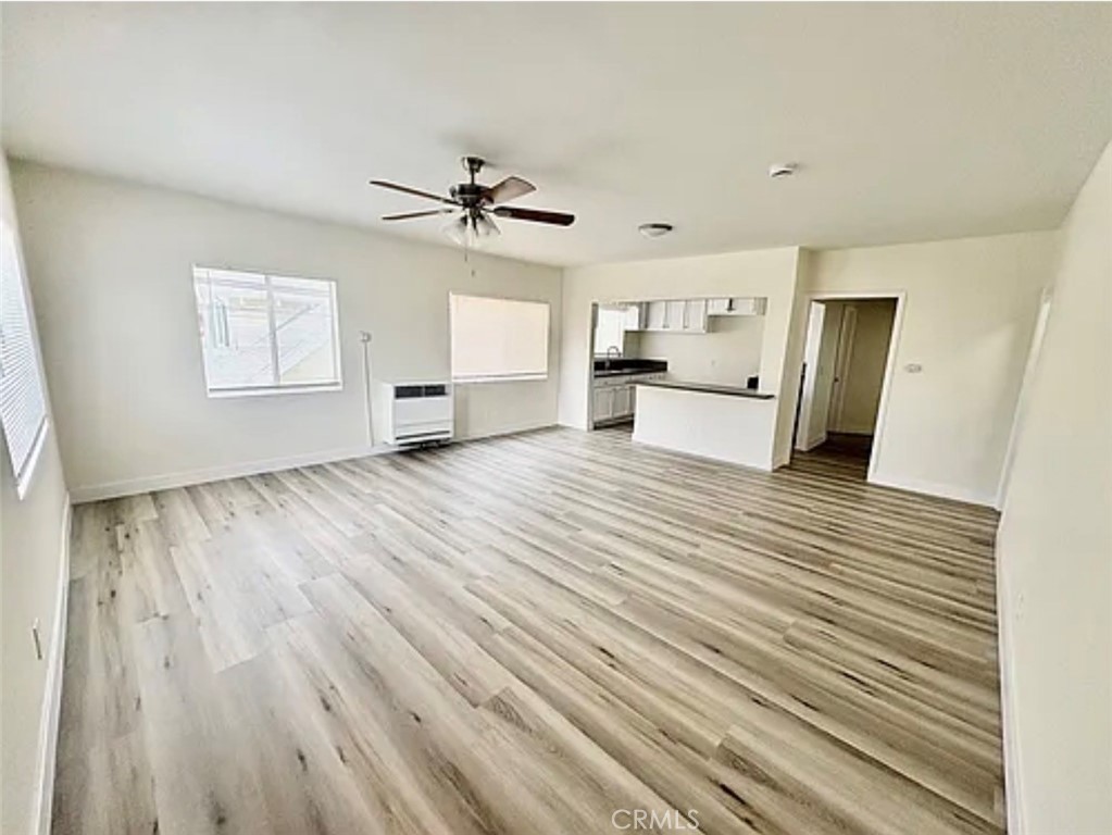 549 East 17th Street, Unit 551 Long Beach, CA 90813 - Photo 3 of 18 a view of a kitchen with wooden floor and a ceiling fan