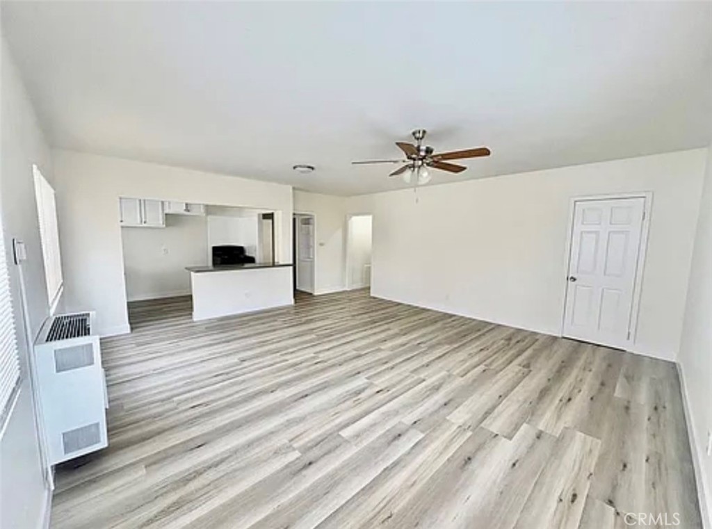 549 East 17th Street, Unit 551 Long Beach, CA 90813 - Photo 4 of 18 a view of a room with a wooden floor and white walls