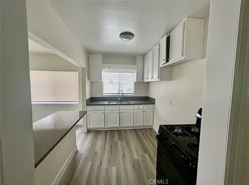 549 East 17th Street, Unit 551 Long Beach, CA 90813 - Photo 6 of 18 a kitchen with granite countertop white cabinets and white appliances